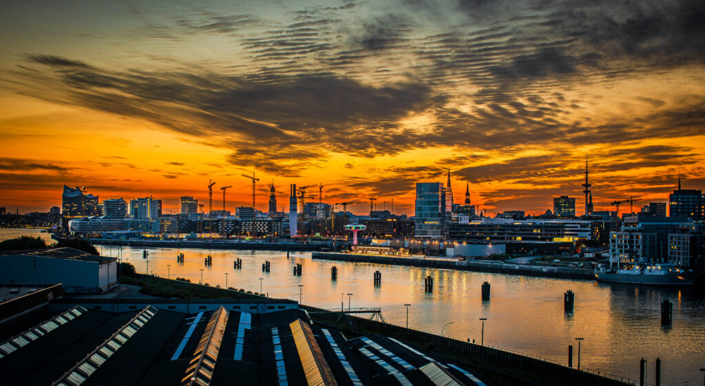Sonnenuntergang über der Skyline mit Elbphilharmonie, Hafen und Fernsehturm in Hamburg.