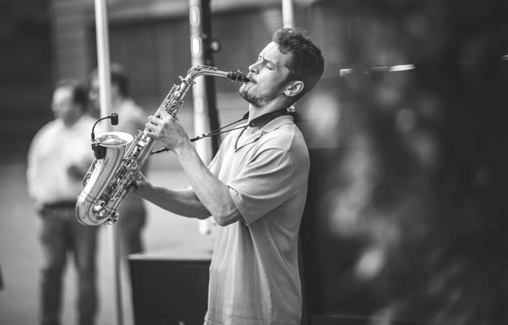 Musiker spielt Saxofon mit geschlossenen Augen, Schwarz-Weiß-Aufnahme voller Ausdruck.