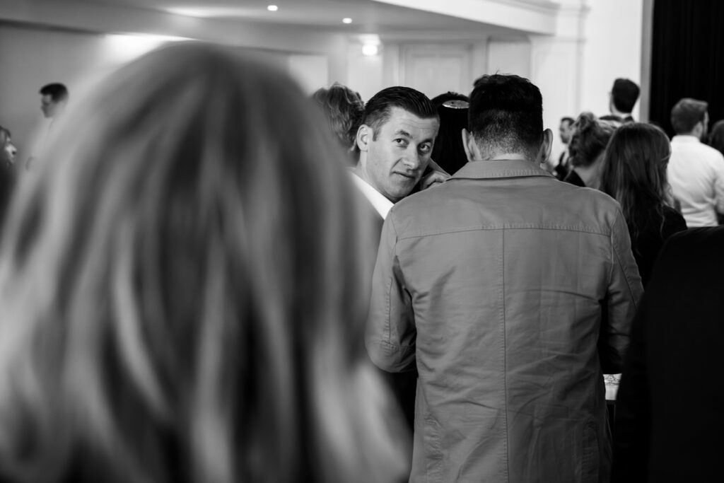 Schwarz-weiß Aufnahme einer Veranstaltung im Curio-Haus Hamburg, ein Mann blickt in die Kamera.