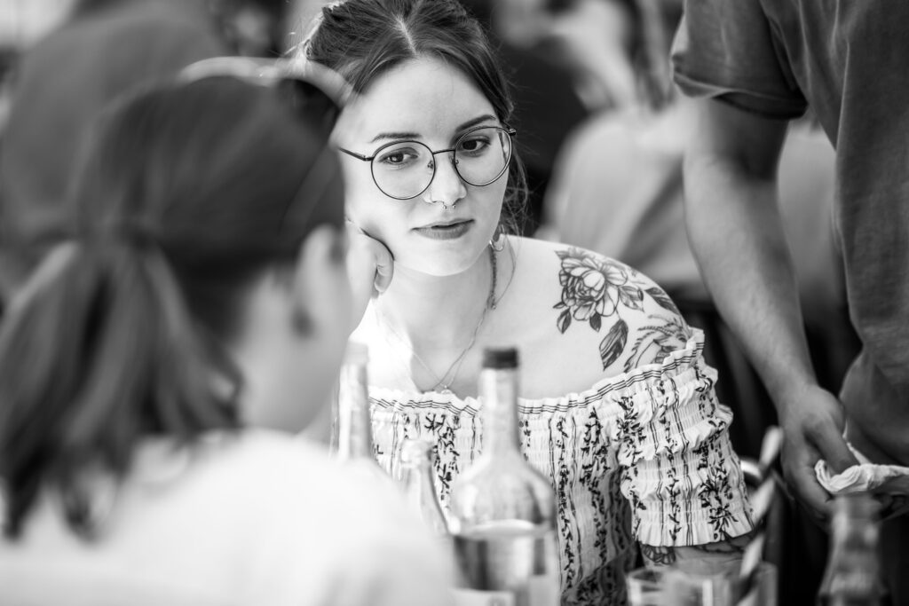 Frau mit Brille und Tattoos sitzt nachdenklich im Restaurant Alte Liebe in Hamburg.