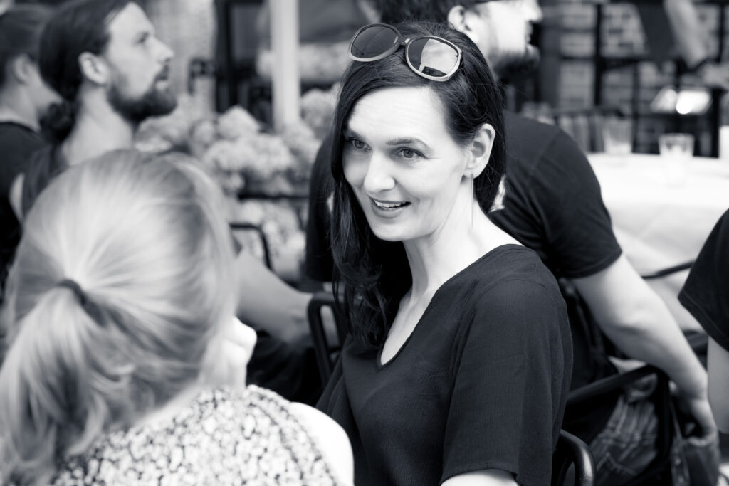 Frau mit Sonnenbrille im Haar unterhält sich auf einer Veranstaltung in der Alten Liebe Hamburg.