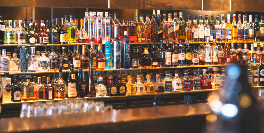 Barregal mit einer großen Auswahl internationaler Spirituosen, ordentlich sortiert und stimmungsvoll beleuchtet.